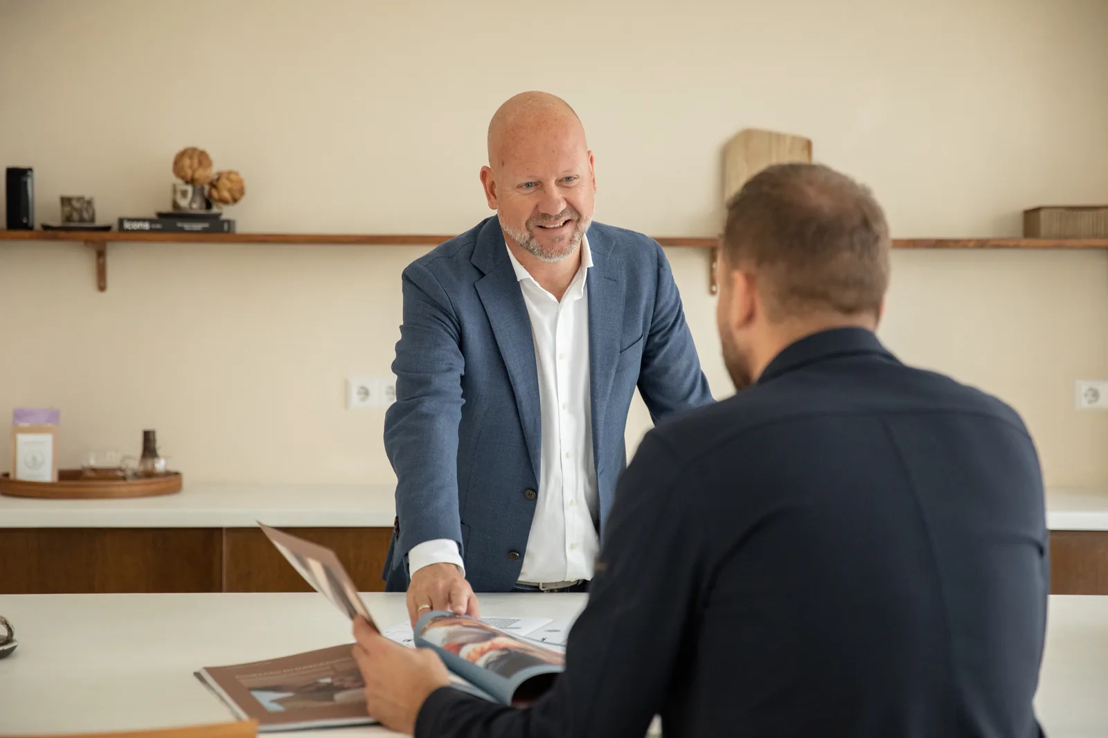 Marco van Mourik bespreekt een brochure met een klant